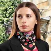 Woman wearing a floral silk twill scarf with a background of the Old Hall Buxton.